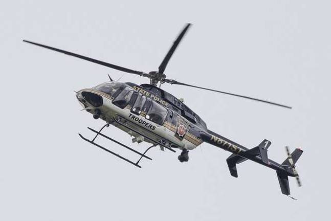 Man hunt continues A Pennsylvania State Police helicopter flies over the fugitive Eric Frein search area.