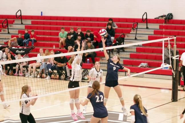 A Spring-Ford Ram strikes the ball while a Delaware Valley Warrior leaps to intercept.