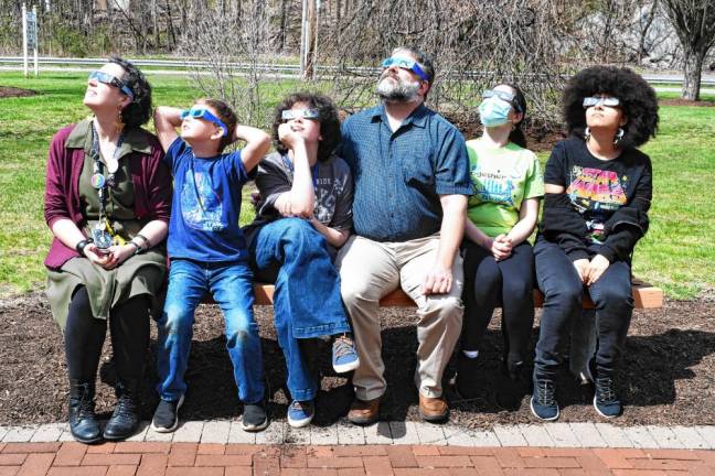 Residents observe the eclipse through safety glasses outside the Dorothy Henry library branch in Vernon. (Photo by Maria Kovic)