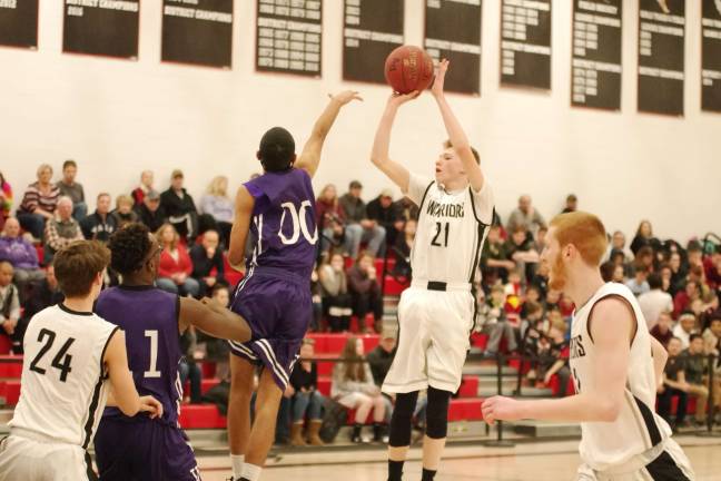 Delaware Valley's Blake Gearhart (21) in the midst of a shot as Wallenpaupack's Izaiah Santiago defends in the first period. Gearhart scored twelve points. (Photo by George Leroy Hunter)