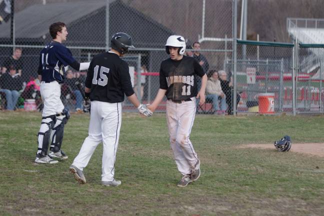 Delaware Valley Warriors suffer season opener loss in baseball and softball After crossing home plate for a score Delaware Valley's Matt Cavallaro (11) gives a teammate a low five.