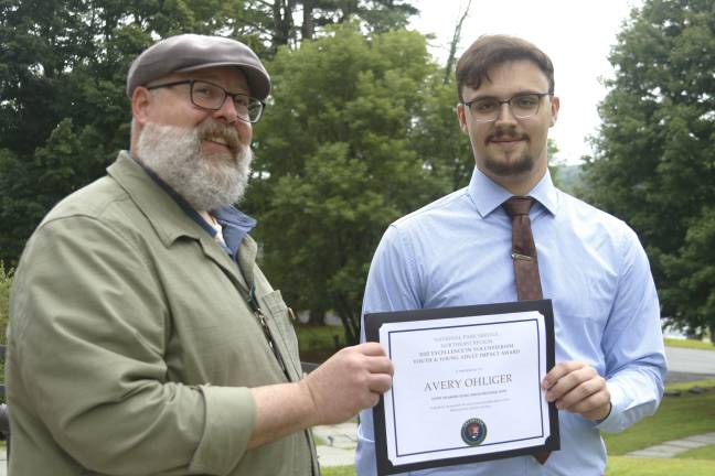 Area volunteer awarded for transcription work Avery Ohliger (right) is presented with the National Park Service’s Region 1 Excellence in Volunteer Service Impact Award by Alex Garcia-Maldonado.