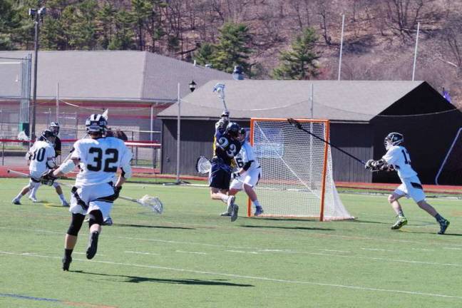 Vernon crushes DV in lacrosse Vernon's Patrick Graham leaps during a score attempt as the Delaware Valley goal keeper stands guard. Graham scored two goals. (Photo by George Leroy Hunter)