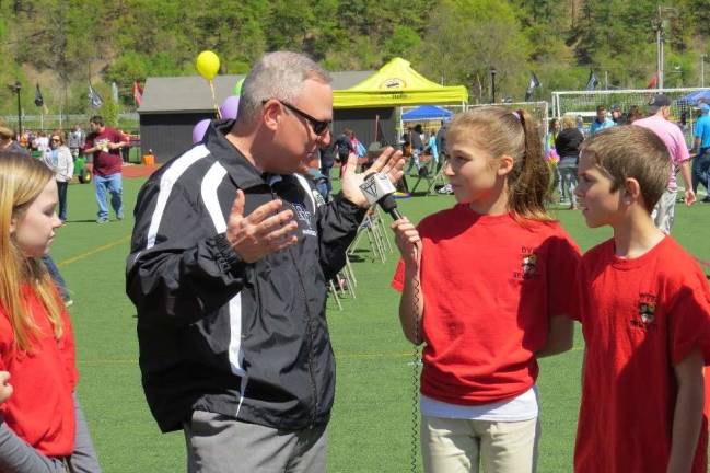 Special Olympics comes to DV Next up for interview was Dr. John Bell, Superintendent of Delaware Valley School District. He spoke about what it was like to be the superintendent. He told us that Delaware Valley has been hosting the Special Olympics for 11 years. He said that he loves the Olympics and that there are about 20 different events held. He was asked what would happen if it rained, and he explained that they always have a rain date and it is usually the next day. Pictured is Dr. Bell with Adrianna Buchanan and Nixon Kameen.