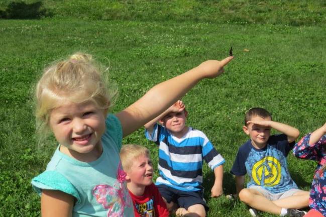 If you see their butterflies, wave goodbye Taryn Kaylor releases a monarch butterfly. Behind her (from left) are Jordain Stoll, Conner Spangenburg, and Kyle Brown (Photo by Peg Snure)