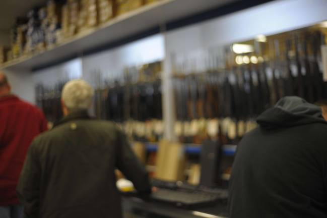 After shooting, a rush to buy guns A man buys a Bushmaster rifle, like the one used in the Newtown, Conn., massacre, on Wednesday at Davis Shooting Sports in Goshen, where customers flocked to make gun purchases. A salesperson told a caller that the shop had run out of the Bushmaster. (Photo by Joshua Rosenau)