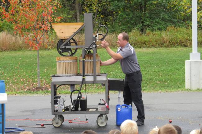 First-graders see how apples turn to cider Mr. Mang pressing and filtering apples. (Photo by Peg Snure)