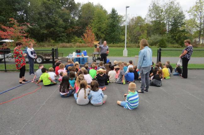 First-graders see how apples turn to cider Mr. Mang explains how apple cider is made. (Photo by Peg Snure)