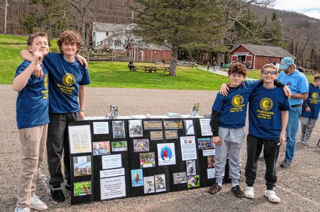 Residents gather to view partial solar eclipse Student Brody Holliday, Ben Sloginski, Tommy Bischoff and Fank Dijon pose in front of Sussex County Bird Club’s exhibit. (Photo by Nancy Madacsi)