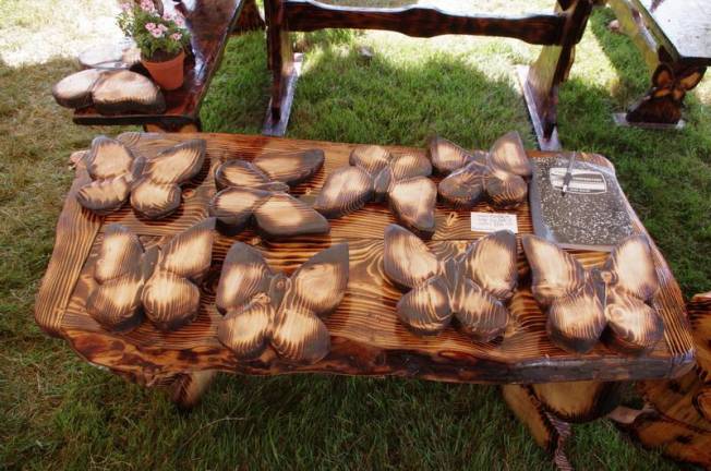 A wooden table is covered with butterflies made of -- you guessed it! -- wood.