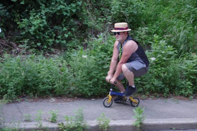 How does he do it? A circus performer rides a tiny clown bike.