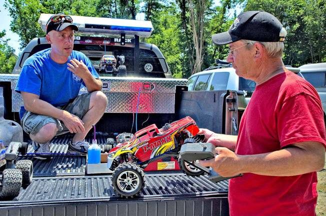 Father and son Nate. left, and Bill Yingling prepare their vehicles for the opening day races.