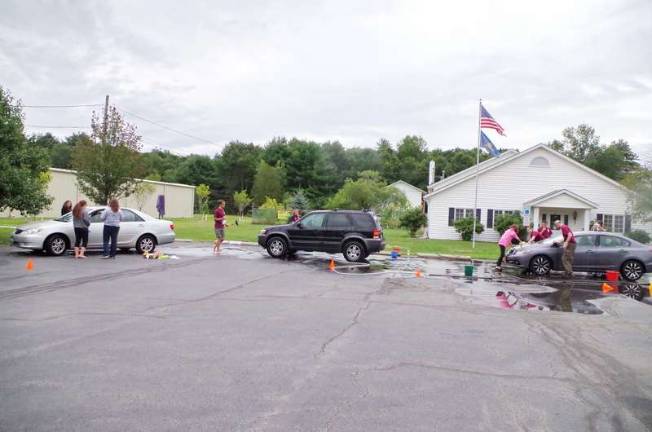 Venturing toward Alaska The crew is busy washing a line of cars.