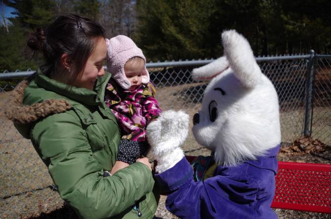 Easter egg hunt 20 month old Pao Lin Fisher of Dingmans Ferry high fives the Easter Bunny.