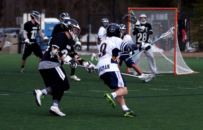 Delaware Valley lacrosse team loses to Vernon Delaware Valley's goal keeper Neil Roche (28) stands ready as Vernon's Brandon Blankman (9) moves the ball towards the goal post.
