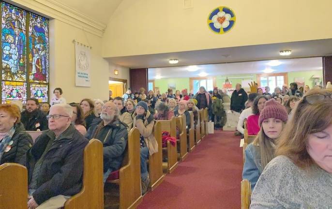 Participants listen to speakers in the St. Peter’s Lutheran Church sanctuary before heading out to march.