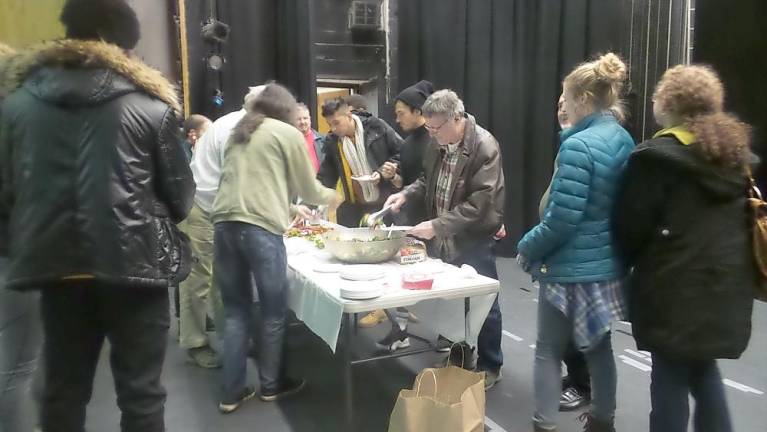 People enjoy wine and cheese on stage after the show