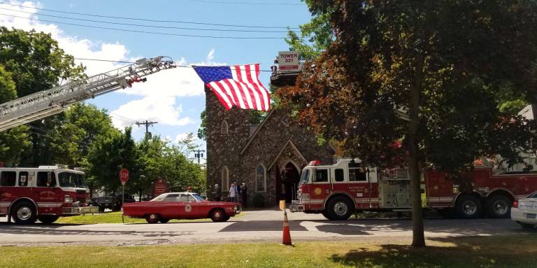 An elegant, heartfelt farewell to Tom Kontizas at Good Shepherd Two local ladder trucks  (Matamoras and Dingman) flank the American flag high above the entrance to Good Shepherd (Photo by Allison Taylor)