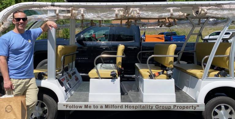 Steven Rosado, Director of Development for the Milford Hospitality Group, with the Jolly Trolley.