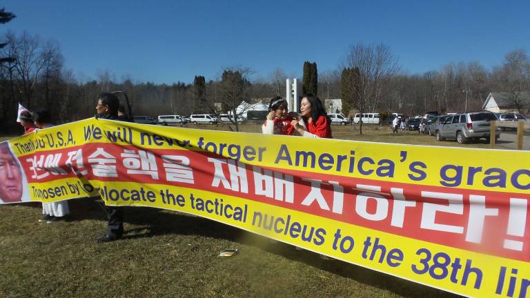 Gun-wielding couples renew their vows Koreans held a sign saying, “Thank you, USA. We will never forger (sic) America’s grace. Trump chosen by God, relocate the tactical nucleus to the 38th line.” (Photo by Frances Ruth Harris) (Photo by Frances Ruth Harris)