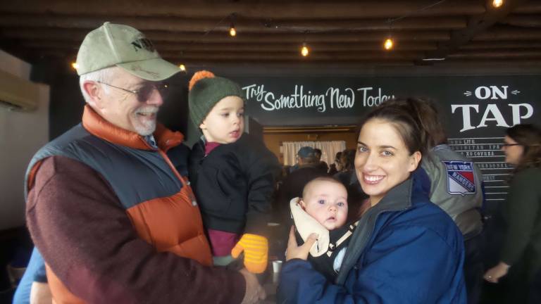 Cooks and tasters agree: Everybody wins Larry Kirwan holding Clayton Swain, while baby Jacob Swain in Jessica Swain’s arms. The tasting is a yearly family event for them. (Photo by Frances Ruth Harris)