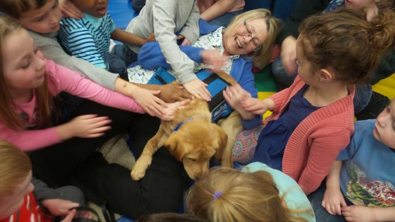 Benni, service dog in training, dazzles preschoolers Benni and his trainer, Chrisanne Cubby, are at the center of a group petting extravaganza at Kids Play Today (Photo by Frances Ruth Harris)