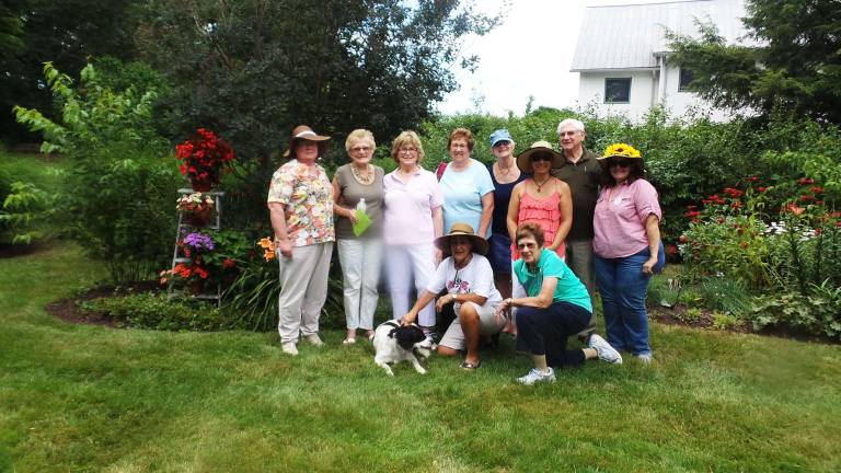 Milford's gardens, revealed Back: Veronica Sierbe, Helga Becking, Sue Daily, Gretel Walker, Chris Allen, Fred Daily, Jenny Dye, Elena Goletz; front: Adriane Wendel and, Lorraine Gregory with Spencer on Herrington House, in Ariane Wendell's garden.