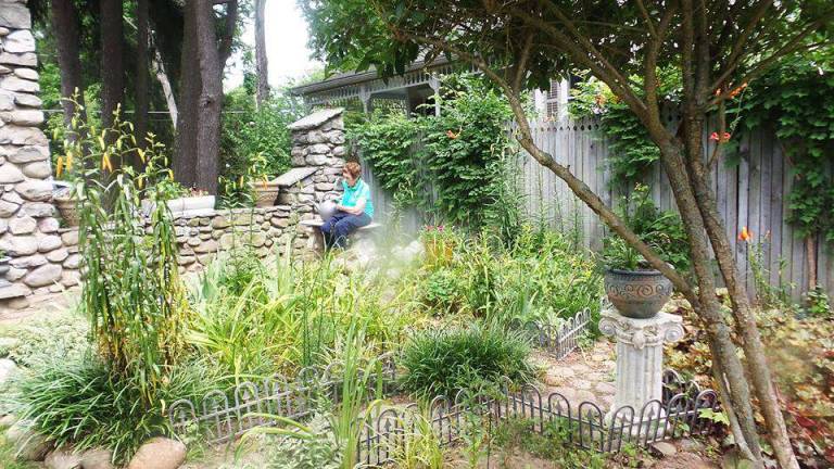 Want to be a Master Gardener? Photo by Frances Ruth Harris Lorraine Gregory rests on a bench in Dennis Fitzpatrick's garden at 210 West Ann St., Milford, which was a stop on last month's "Secret Garden Tour" hosted by the Milford Garden Club.