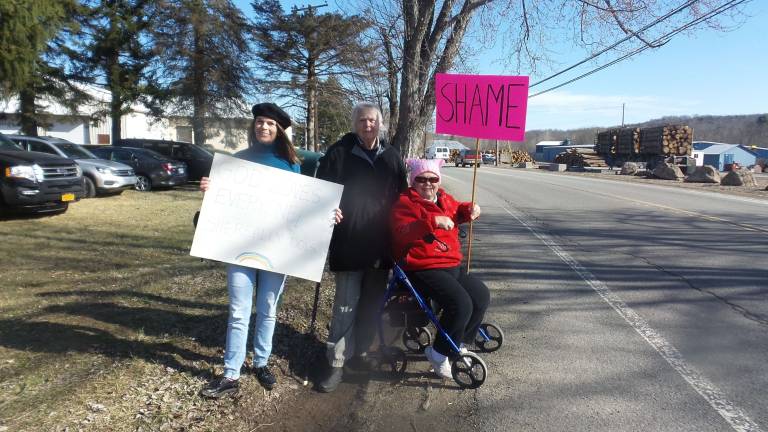 Gun-wielding couples renew their vows Protestors outside the church (Photo by Frances Ruth Harris)