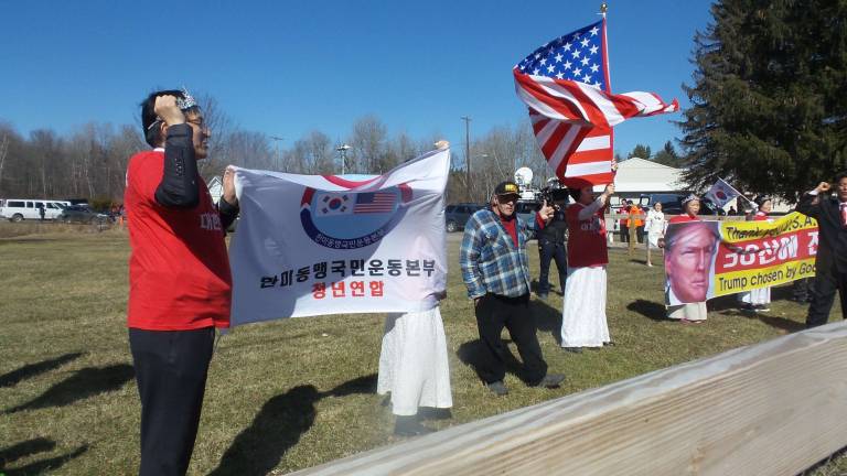 Gun-wielding couples renew their vows Koreans faced off with protestors following services. The sign says, “Thank you, USA. We will never forger (sic) America’s grace. Trump chosen by God, relocate the tactical nucleus to the 38th line.” (Photo by Frances Ruth Harris)