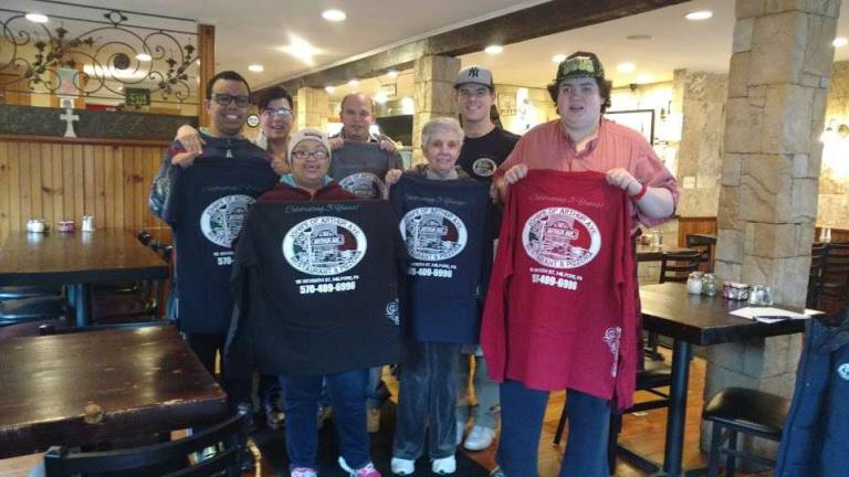 Devereaux visitors learn pizza business from a pro The visitors from Devereux show off their new T-shirts (Photo by Anya Tikka)
