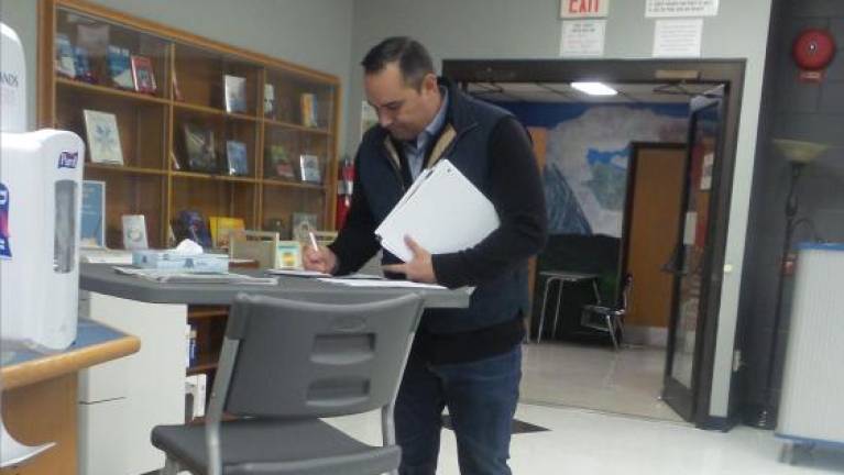 Matthew Contreras signed in to make a public comment before the work session in the high school library. (Photo by Frances Ruth Harris)