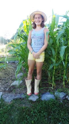Hannah Williams in front of developing sweet corn (Photo by Frances Ruth Harris)