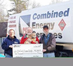 Chris Roberts (left) and Dan Driscoll (right) presented Barry Heim, executive director of the the Pike County Humane Society, with funds for fuel oil that the shelter uses to heat their buildings.
