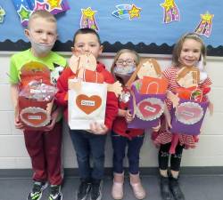 Students from Mrs. Janel Stewart’s first-grade class show off their home-made Valentine’s bags (from left): Dominick Ulbrich, Carson Constantine, Irish Hughes, Kiralee Moore (Photo by Peg Snure)