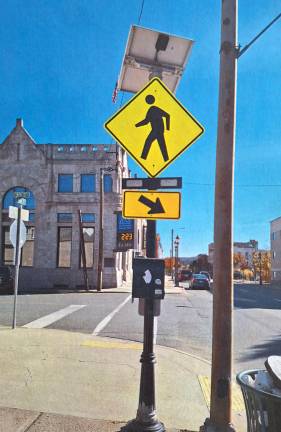 A crosswalk sign made to help pedestrians cross the street safely and with less anxiety.