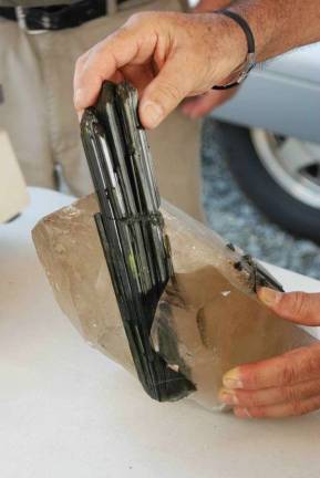 James Hadley cuts a large chunk of green tourmaline in quartz (Hadley's Earth Crystals Facebook page)