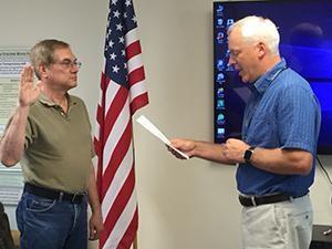 New board member Jay Morrow (left) was sworn in by commissioner board member Ronald Schmalzle (right)