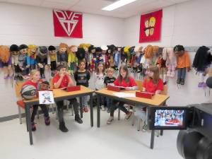 Kindergartners are interviewed by DVE-TV reporters on their morning show. Pictured (from left): Chelsey Samson, Rocco Paradiso, Aaliyah Rivera, Lyla Barry, James May, Amaya Ruiz, Maggie Sutton, and Peyton Copertino (not pictured). (Photo by Peggy Snure)