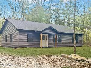 Newly constructed raised ranch is in a private wooded settin