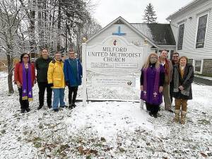 Rev. Dr. Eunice Vega-Perez far left, church pastor Rev. Jenn Lovallo just to the right of the sign, the Reconciling Ministries Team