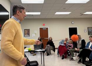 David Richard reciting a poem holding a Poi, an ancient Maori object used to help keep the rhythm of presenting a poem or story.