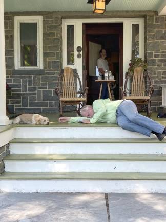 At a rehearsal for Ages of the Moon on Beth Kelley’s Porch, Toby, her dog, hovers over John Klemeyer, thinking he has really passed out. Roy Wilbur and Kelley are in background.