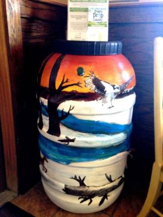 A raptor soars over a winter scene on this decorated rain barrel (Delaware Conservancy Facebook photo)