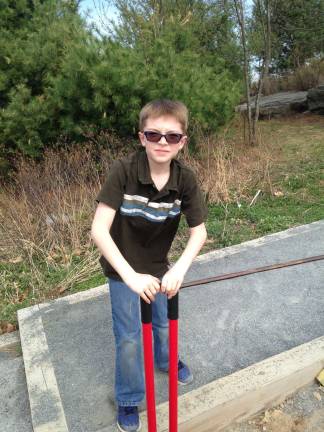 Jaden Latini learns to use the post hole digger (Photo provided)
