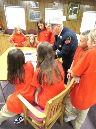 The reporters looking at Lt. Rennish’s newspaper clippings and books about 9/11.