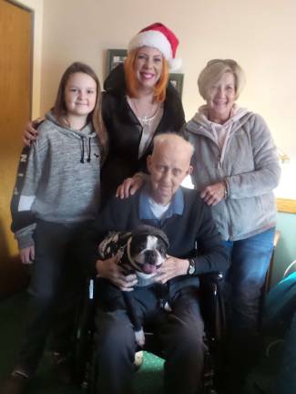 From left: Avery, Ken Tinqust’s great-granddaughter; President of Milford’s Ausiliary, Katie Jo Kardel; Sandy, Ken’s daughter; and Navy Sailor Ken Tinquist holding fuzzy Sherlock Holmes, dressed as the great detective for which he is named, complete with his hat. (Photo by Frances Ruth Harris)