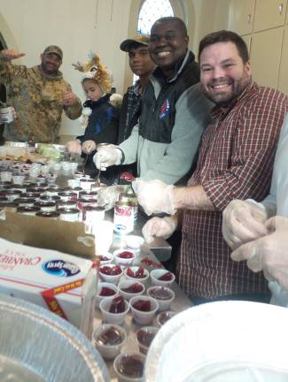 Volunteers in the kitchen create 125 individual portions of cranberry sauce.