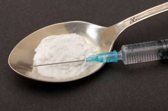 Syringe, spoon and heroin, concept of addiction