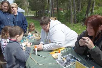 Shelly Lunsenbigler and Terry Finlayson show children how to make little mice out of milkweed pods at the Pocono Environmental Education Center (File photo by Marta Serra-Jovenich)